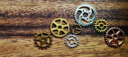 Mechanical engagement vintage gears on wooden surface artistic display home environment close-up viewの写真素材