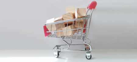 Shopping cart filled with wooden blocks indoor setting product photography minimalist design close-up perspectiveの写真素材