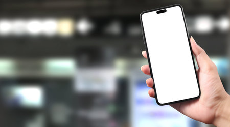 Hand holding a smartphone device and touching screenの写真素材