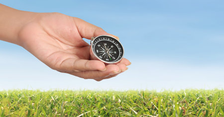 Hand holding a compass symbolizing direction and navigationの写真素材