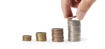 Hand laying coins on stacks coins in  row