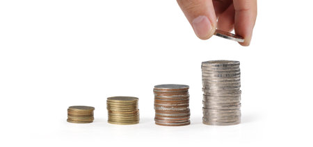 Hand laying coins on stacks coins in  row