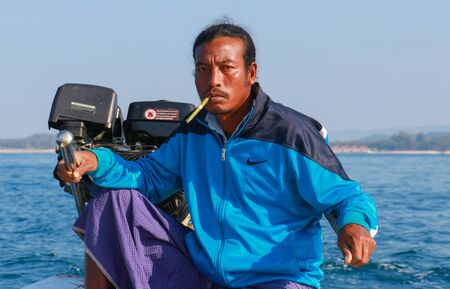 Ngapali, Myanmar - February 3, 2019: Burmese boatman smoking in the boatのeditorial素材