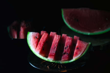 sliced juicy ripe watermelon on a dark background for the menuの写真素材