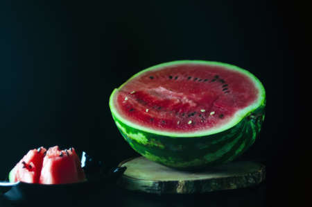 sliced juicy ripe watermelon on a dark background for the menuの写真素材
