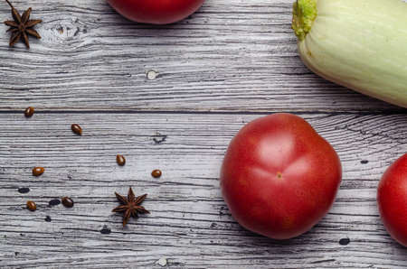 red juicy tomato top view on vintage wooden background with zucchini with place for an inscriptionの写真素材