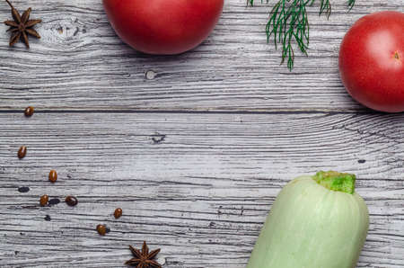 red juicy tomato top view on vintage wooden background with zucchini with place for an inscriptionの写真素材