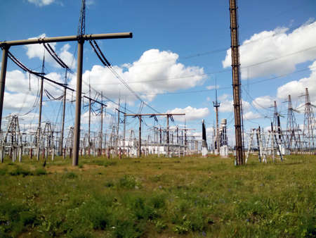 high-voltage electrical towers on a background of blue sky with cloudsの写真素材