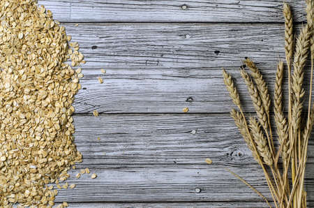 oatmeal scattered on a wooden table top view with a place for inscription.の写真素材