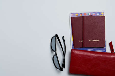 Two passports with a leather red wallet and sunglasses on a white background for customs top view. place for textの写真素材