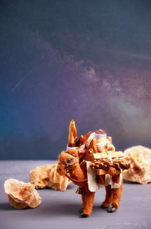 a toy camel from a caravan carries cargo in the night desert.の写真素材