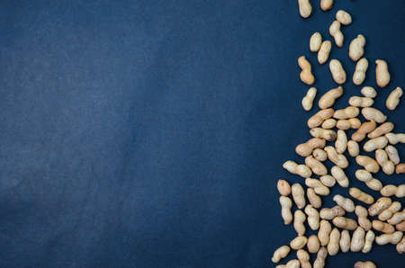 Handful peanuts on a dark background, top view with place for text, copy past, flat layの写真素材