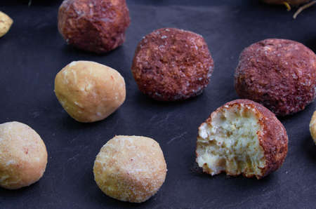 Raw food sweets made from peanuts, coconut and cocoa are on a black slate board.bittenの写真素材
