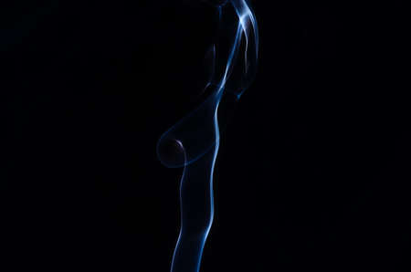 Abstract puffs of smoke on the left side of the frame on a dark background with a place for text, mysticism, fantasy,magicの写真素材