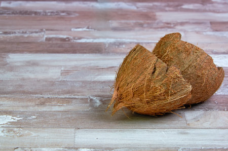 empty coconut shell on a wooden table close-up with place for text