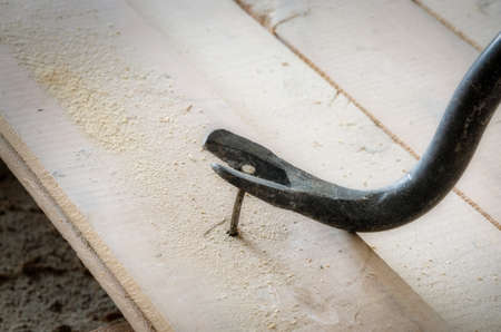 Nail puller pulls an old nail from the floorboardの写真素材