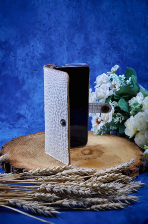 Phone case made of genuine white caiman leather, handmade, do it yourself, on a blue backgroundの写真素材
