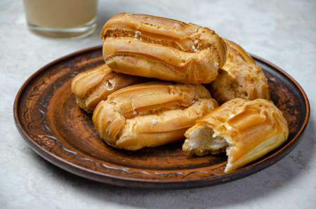 eclairs on a brown clay plateの写真素材