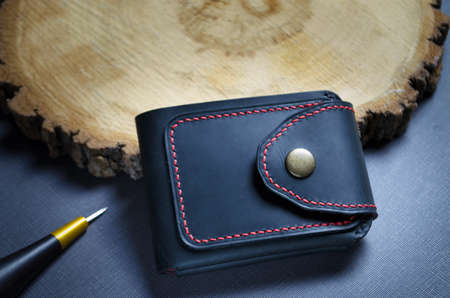 mens black wallet made of genuine leather stitched with red threads, handmade, with a place for textの写真素材