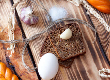 black bread with garlic and egg on a wooden backgroundの写真素材