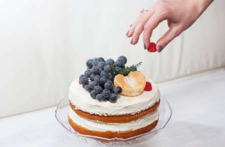 Biscuit cake with fruit hat on a white backgroundの写真素材