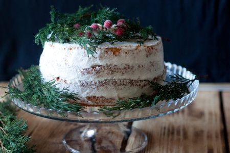 Sponge cake garnished with fresh berries and rosemary
