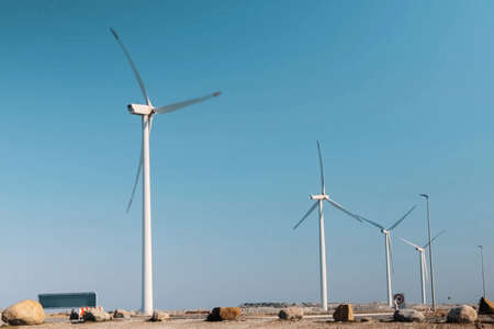 Wind farms in the countryside against a blue sky.の写真素材