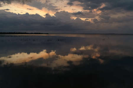 The sky is in zagon with clouds above the pond. Sunset time.の写真素材