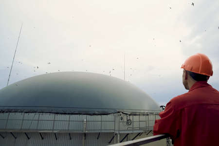 Novosibirsk, Russia - June 20, 2019: Biogas station. Biological gas plant. A man in a helmet looks at a gas tank. Biogas station. Biological gas plant.のeditorial素材