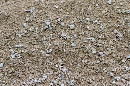 A close-up, top-down view of loose aggregate material, composed of small brown pebbles and white gravel.の写真素材
