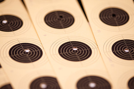 A close-up, shallow depth of field view of multiple light beige shooting targets with concentric black circles and a central bullseye.の写真素材