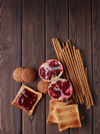 Different buns of fresh bread and spikelets of wheat on a brown vintage background