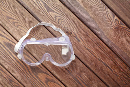 Plastic safety goggles on wooden backgroundの写真素材