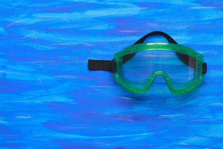 Plastic safety goggles on blue backgroundの写真素材