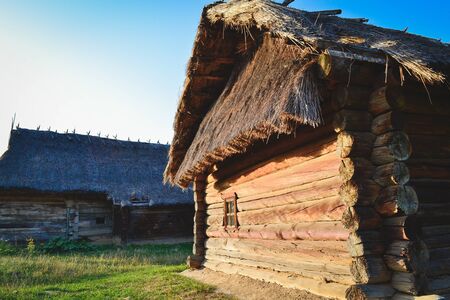 Old wooden house in the Ukrainian village. The traditional housing for the residents of the Ukrainian village. The roof is made of strawの写真素材