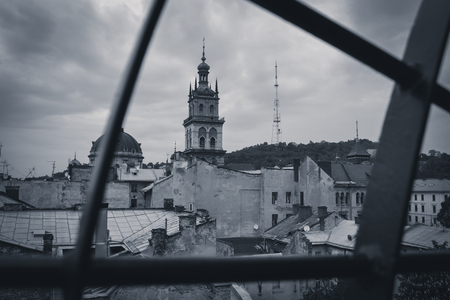 Black and white photography. View of the town hall from the roof of an old house in cloudy weather. Lviv, Ukraineの写真素材
