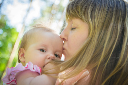 Young mother with her little baby. Loving mother takes care of her daughter