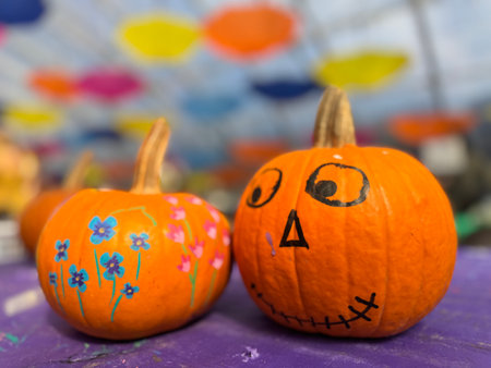 Halloween pumpkins with funny faces on purple wooden background. Close up.の写真素材