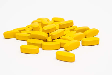a lot of yellow pills isolated on a white backgroundの写真素材