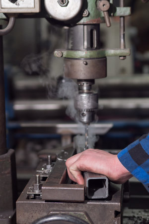 a man in a blue shirt drills a hole in the details.