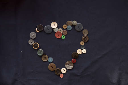 Button for sewing in the form of a heart on a blue fabric.の写真素材