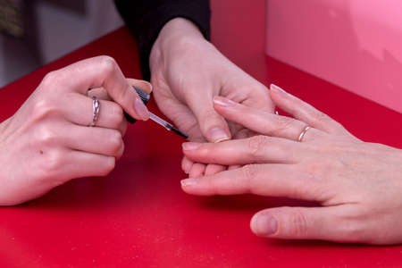The girl at table does her manicureの写真素材