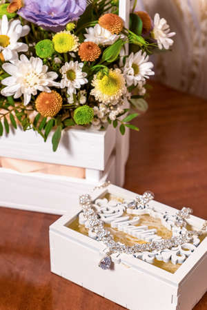 wedding necklace in a box near flowersの写真素材