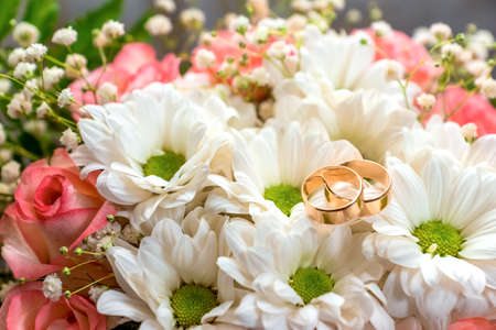 wedding rings lie onb a beautiful bouquetの写真素材