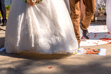 The bride and groom are stepping on the towel. Slavic traditions.