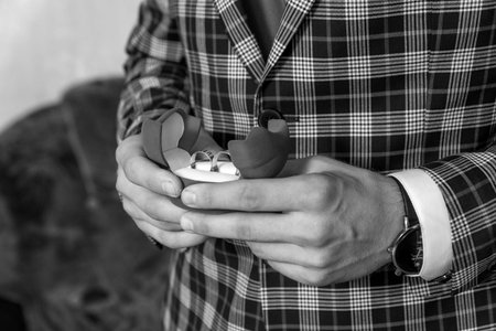 the groom in a suit holds rings