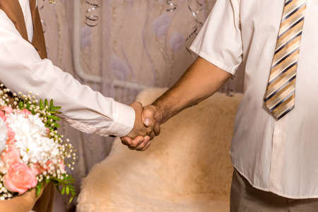 the brides father shakes hands with his son-in-law.の写真素材