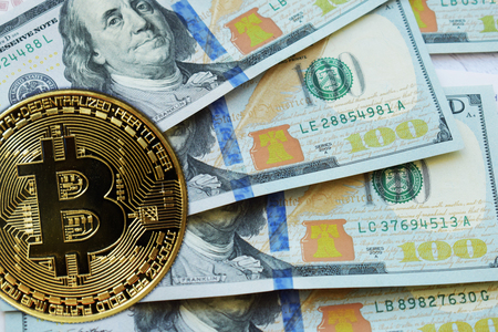 Golden Bitcoins on US dollars. Digital currency close-up. New virtual money. Crypto currency top view. Real coins of bitcoin on banknotes of one hundred dollars. Exchange. Bussiness, commercial.の写真素材