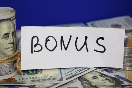 100 dollar bills twisted into a pipe and tied with string. Bonus concept.の写真素材
