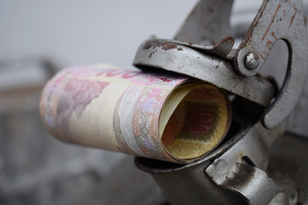 Metal barrel and Ukrainian money, the concept of the cost of gasoline, diesel, gas. Refilling the car. Roll of banknotes 100 hryvniaの写真素材